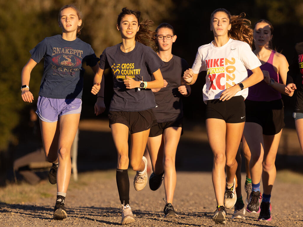 Montgomery runners Seelah Kittelstrom, left, Hanne Thomsen, center, and Amrie Lacefield, right, during a training run at Spring Lake last year. (John Burgess / The Press Democrat)