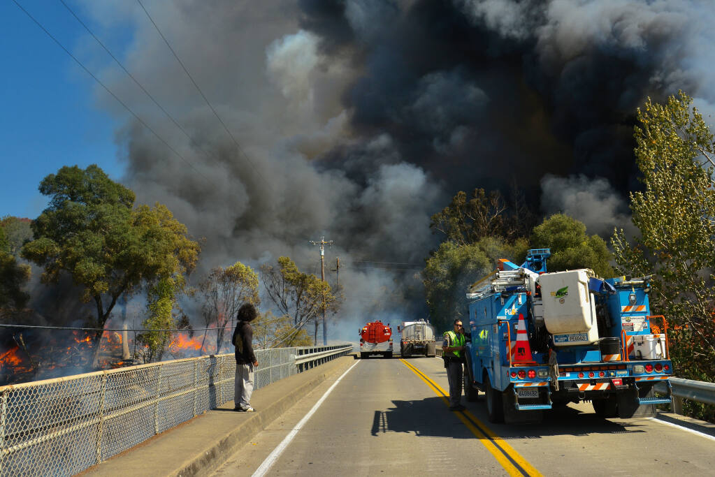 The man authorities suspect of starting the Hopkins fire in Calpella stands on the Moore Street bridge watching the flames on Sunday, Sept. 12, 2021. (Peter Armstrong)