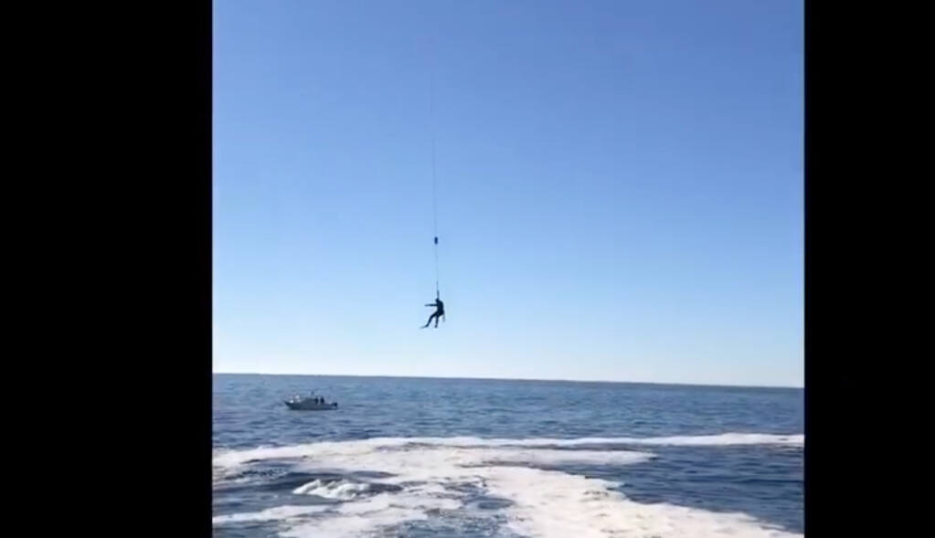 In this screenshot from a video posted to Facebook, a rescue paramedic saves a man who fell into the Pacific Ocean near Fort Ross State Historic Park on Monday, Oct. 27, 2020. (Sonoma County Sheriff’s Office/Facebook)