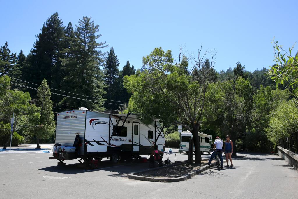 Residents of two campers park in the Guerneville Park and Ride lot on Highway 116 in Guerneville on Monday. (The Press Democrat)