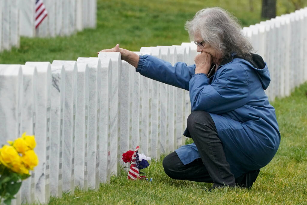Etta Sauers of North Huntingdon, Pa, visits the grave of her husband Roy W. Sauer, a Navy veteran at the National Cemetery of the Alleghenies in Cecil Township, Pa, on Veteran's Day, Wednesday, Nov. 11, 2020. (AP Photo/Gene J. Puskar)