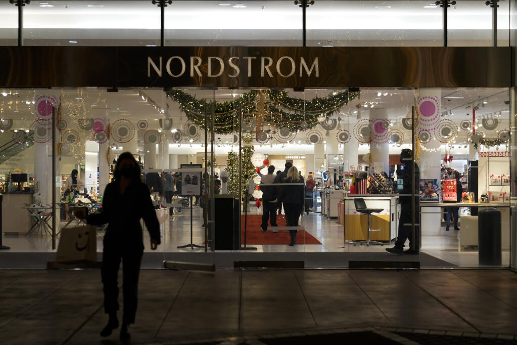 A security guard, right, stands at the entrance to a Nordstrom department store at the Grove mall in Los Angeles, Thursday, Dec. 2, 2021, where a recent smash-and-grab robbery took place. (AP Photo/Jae C. Hong)