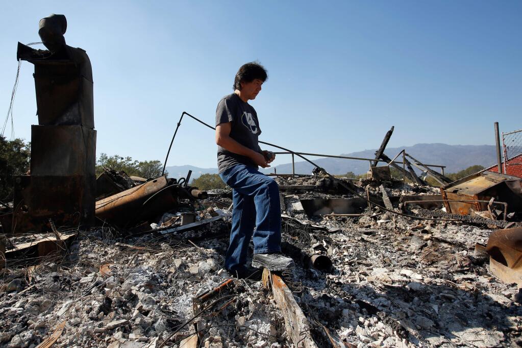 Brian Williams stands in the ruins of his family's home that was destroyed by the Redwood Complex fire at the Redwood Valley Rancheria band of Pomo Indians in Redwood Valley, California on Friday, October 13, 2017. (Alvin Jornada / The Press Democrat)