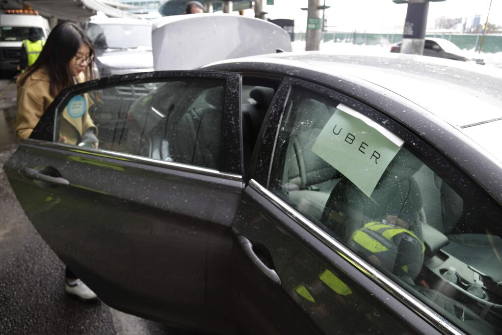 FILE - In this March 15, 2017, file photo, a woman gets in an Uber car at LaGuardia Airport in New York. (AP Photo/Seth Wenig, File)