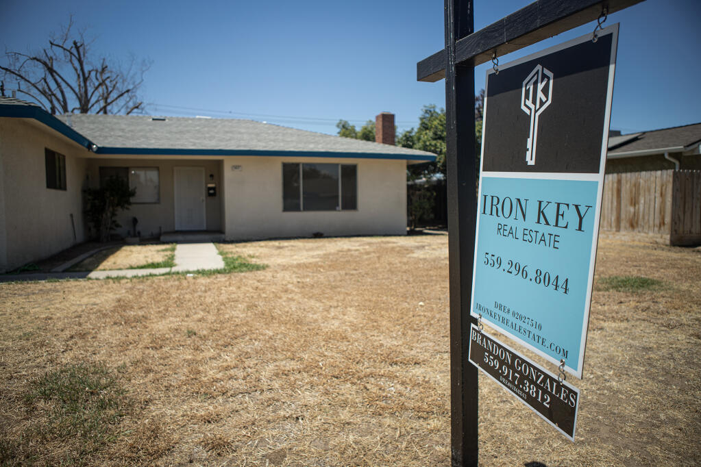 A sale sign in front of a home in the Tower District in central Fresno on June 28, 2022. Photo by Larry Valenzuela, CalMatters/CatchLight Local