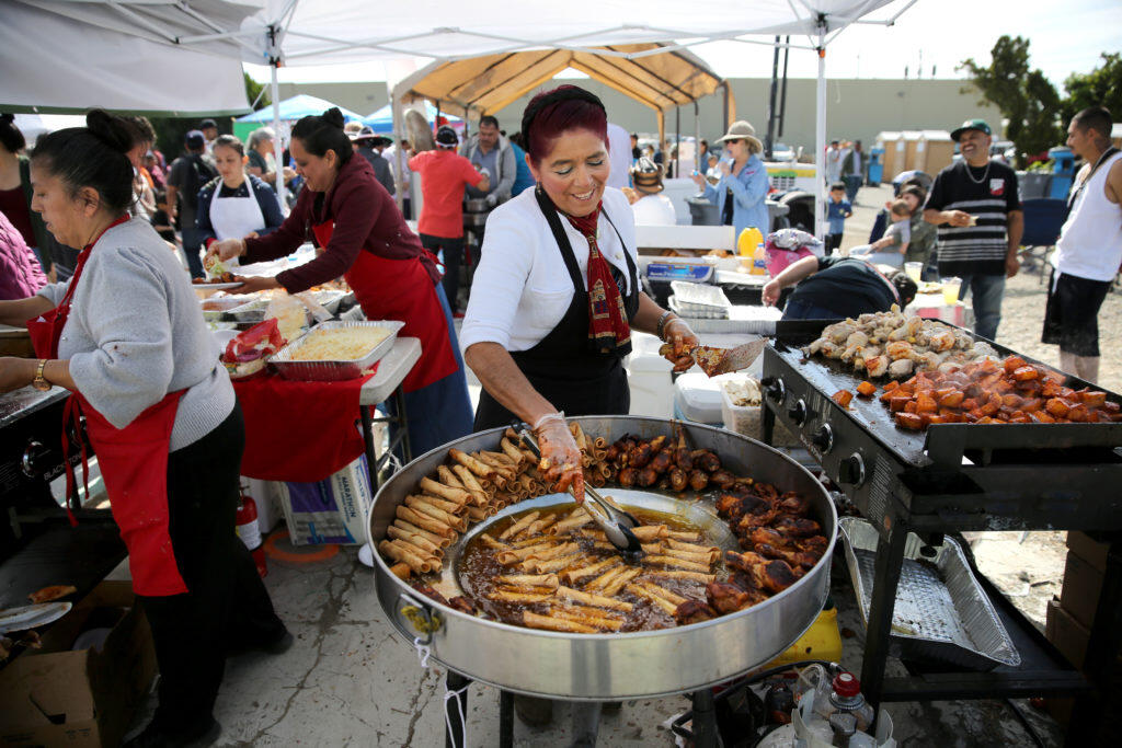 Olivia Estrada cooks flautas as she works the frier at a food booth during the Cinco de Mayo celebration at the Roseland Village Shopping Center in Santa Rosa on Sunday, May 5, 2019. (BETH SCHLANKER/ The Press Democrat)