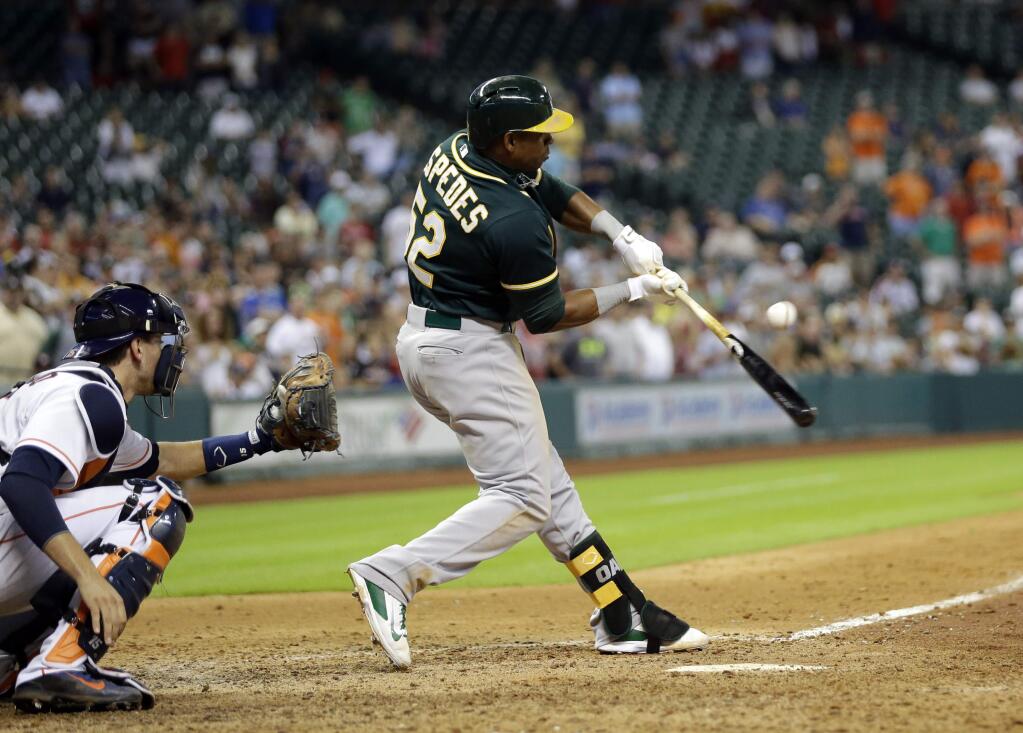Oakland Athletics' Yoenis Cespedes (52) hits an RBI-single to score John Jaso to tie the game as Houston Astros catcher Jason Castro, left, reaches for the pitch during the ninth inning of a baseball game Tuesday, July 29, 2014, in Houston. (AP Photo/David J. Phillip)