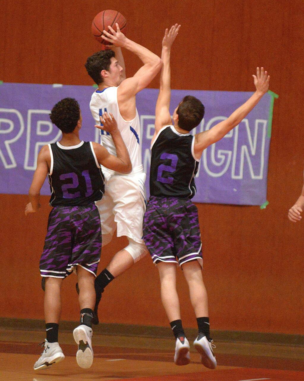 SUMNER FOWLER/FOR THE ARGUS-COURIERAnaly's Dom Tripodi fires over Petaluma defenders Trey Davis (21) and Austin Paretti (2) for two of the 16 points he scored in Analy's win in the SCL Tournament championship game.