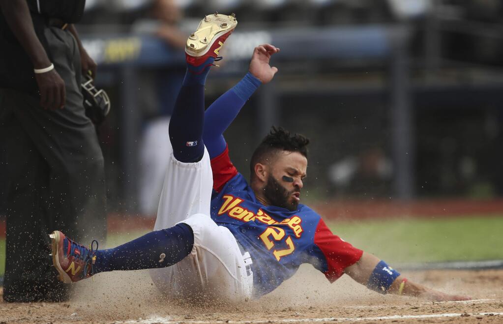 In this Saturday, March 11, 2017 photo, Venezuela's Jose Altuve scores a run in the fifth inning of a World Baseball Classic game against Italy, in Guadalajara, Mexico. Venezuela got past Italy 4-3 and into the second round of the classic to face the United States in the Pool F opener in San Diego. (AP Photo/Luis Gutierrez)