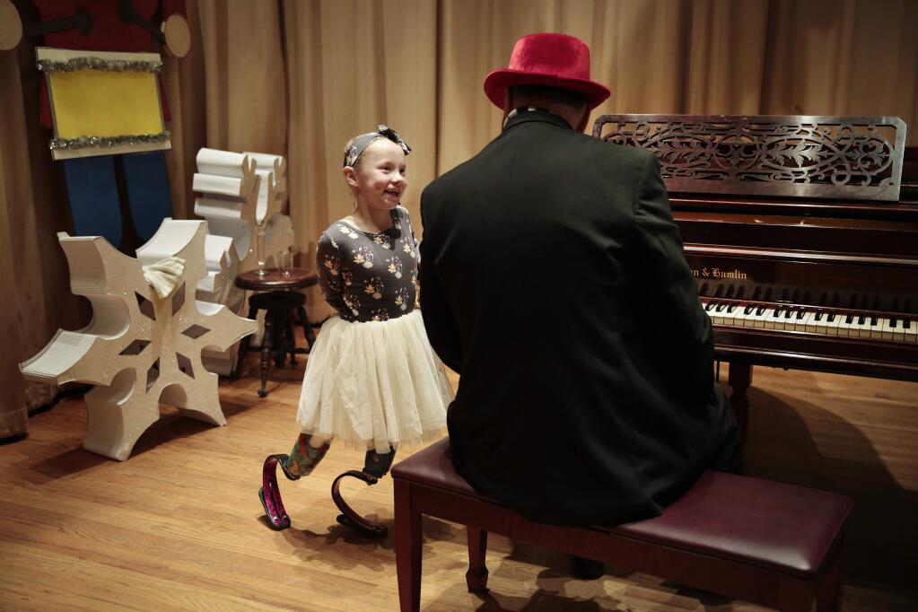 Lilly Biagini, 9, joins Petaluma Pete (John Maher) on stage at the annual Festival of Trees fundraiser put on by Fabulous Women of Sonoma County and The Petaluma Woman's Club at the Petaluma Women's Club on Saturday, December 3, 2016 in Petaluma, California. (RAMIN RAHIMIAN for The Press Democrat) Lilly announced that the first grant that Fabulous Women of Sonoma County would give out in 2017 is to Giant Steps, a therapeutic equestrian center in Petaluma. Lilly had voluntary double amputation to avoid life in a wheelchair as a result of having Arthrogryposis Multiplex Congenita (AMC). AMC is a group of nonprogressive conditions that cause multiple joint contractures (stiff joints) and abnormal muscle development. (RAMIN RAHIMIAN for The Press Democrat)