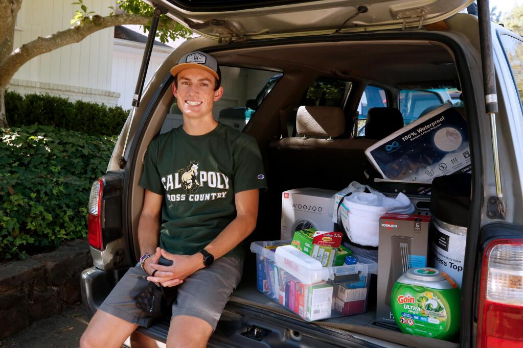 Colton Swinth sits beside some of the items he is bringing to furnish his dorm room when he starts his freshman year at Cal Poly San Luis Obispo this fall, at his home in Santa Rosa, on Thursday, July 30, 2020. (Alvin Jornada / The Press Democrat)
