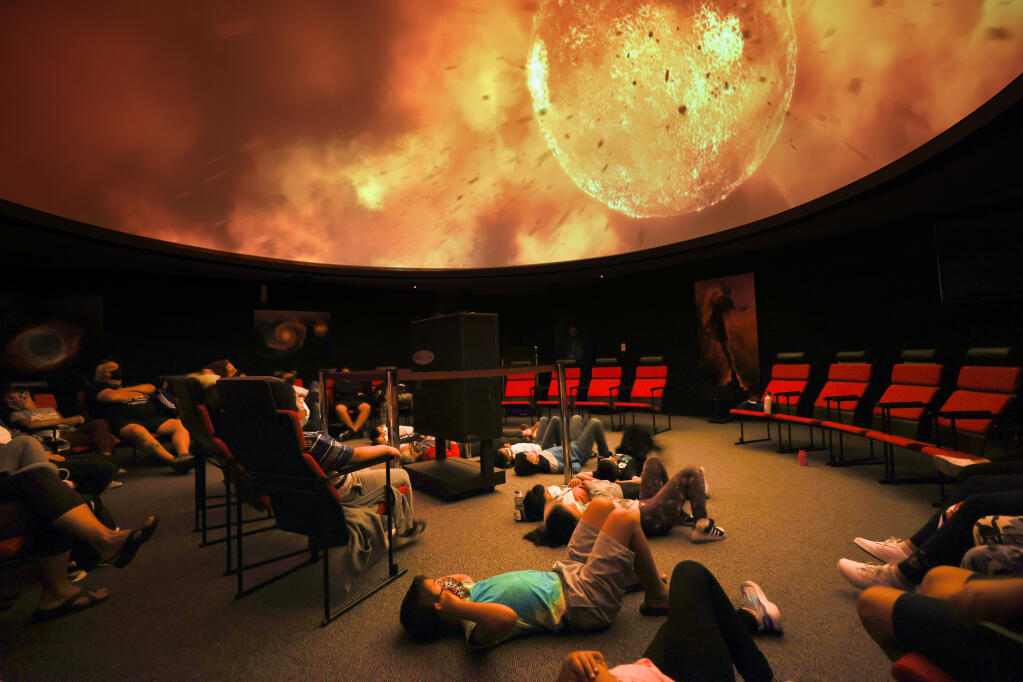 Children in Space Camp watch a movie about the universe at the SPARQ Planetarium at Piner High School in Santa Rosa on Thursday, July 29, 2021.  (Christopher Chung/ The Press Democrat)