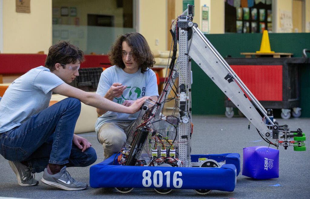 Daniel De Leon works with Carlo Woolsey as members of the Credo High Eco Robotics team work on testing and troubleshooting their robot “Clawdia” during a test drive at Credo High in Rohnert Park, Monday, March 27, 2023. (Chad Surmick / The Press Democrat)