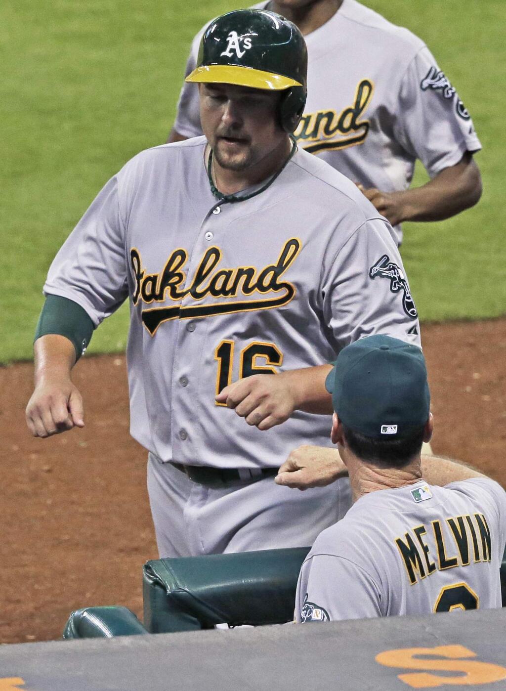 Oakland Athletics' Billy Butler (16) is welcomed back to the dugout by manager Bob Melvin after scoring on a Stephen Vogt single against the Houston Astros in the sixth inning of a baseball game Tuesday, April 14, 2015, in Houston. (AP Photo/Pat Sullivan)