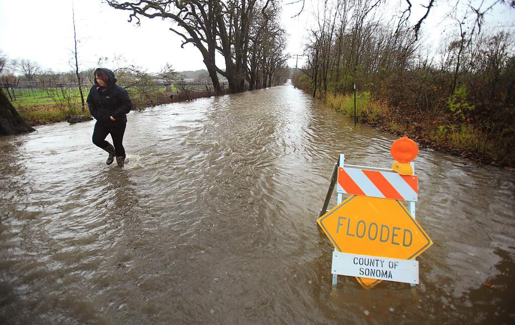 A Windsor woman who declined to give her name wanted to see how deep the water was at Mark West Station and Starr Roads in Windsor before driving through. She turned around, Wednesday Jan. 6, 2016. (Kent Porter / Press Democrat ) 2016