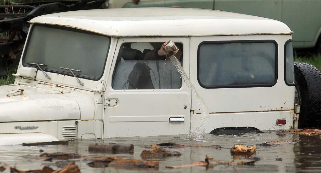 An employee of Mudrak Custom Cruisers bails out a jeep stuck in floodwaters in Sonoma on Thursday, Dec. 11, 2014. (KENT PORTER/ PD)