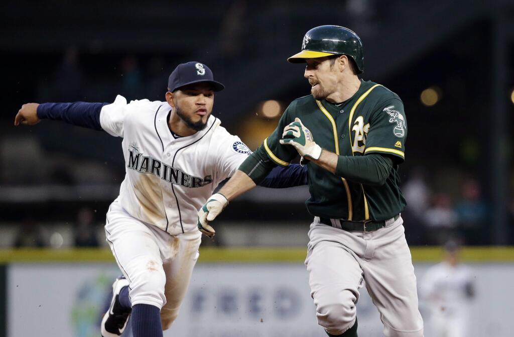 Seattle Mariners shortstop Luis Sardinas, left, lunges to tag out Oakland Athletics' Billy Burns on a rundown between first and second bases in the fifth inning of a baseball game Wednesday, May 25, 2016, in Seattle. (AP Photo/Elaine Thompson)