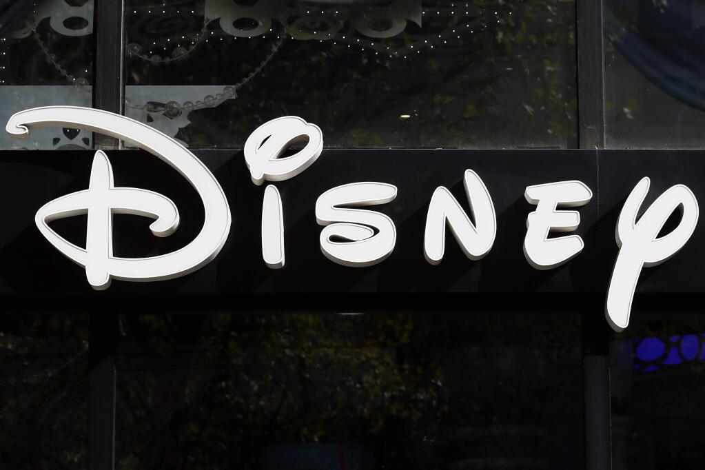 FILE - This Sept. 20, 2017, file photo shows a sign at the Disney store on the Champs Elysees Avenue in Paris, France. The Walt Disney Co. reports earnings Tuesday, Feb. 6, 2018. (AP Photo/Francois Mori, File)
