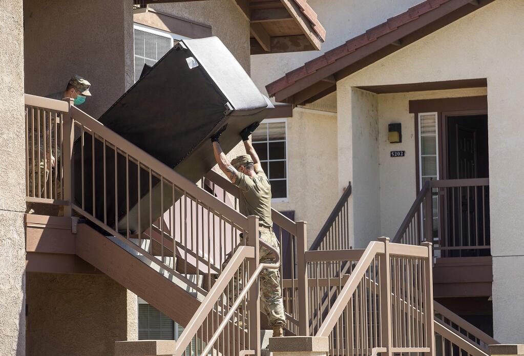 Soldiers with the National Guard 349th out of Vallejo remove furniture from SSU dorm rooms which will become available for people exhibiting Covid-19 symptoms and are awaiting testing results. The guard is also setting up 110 beds in the SSU Recreation Center for active Covid-19 patients. (photo by John Burgess/The Press Democrat)