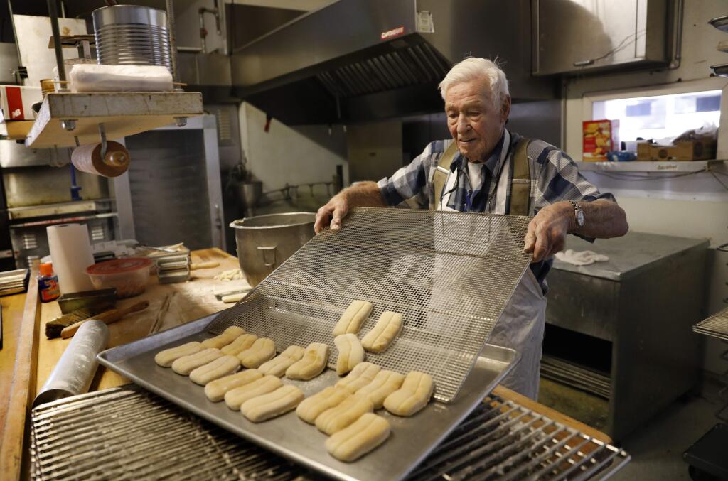 Frank Whigham transfers buttermilk bars to a baking sheet at Donut Cafe on Thursday, January 10, 2019 in Santa Rosa, California . (BETH SCHLANKER/The Press Democrat)