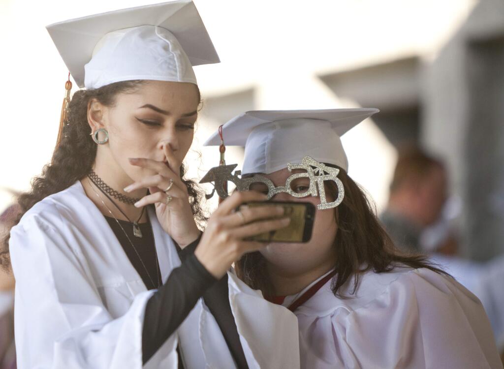 Petaluma, CA, USA. Wednesday, June 01, 2016_ (L) Joely Smithwick and Joy Young of San Antonio High School, prepare for the graduation ceremony and take selfies outside of the auditorium. Students from the Alternative High Schools of Petaluma - Carpe Diem HS, San Antonio HS, Sonoma Mountain HS, Valley Oaks HS - graduated on June 01, 2016 at the Community Center in Lucchesi Park. (CRISSY PASCUAL/STAFF PHOTOGRAPHER)