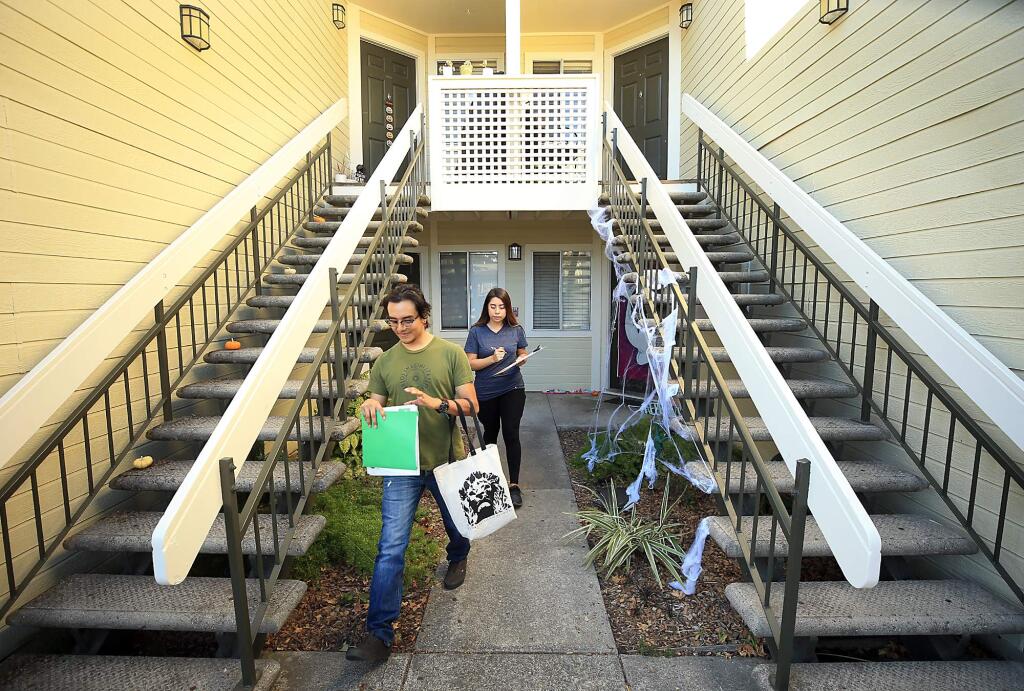 Milton Conteras, 20, and Jennifer Cabrera, 21, canvas apartments around Bay Village Circle in Santa Rosa, Monday, Oct. 15, 2018 to get out to the Latino and and Hispanic voter. (Kent Porter / The Press Democrat) 2018