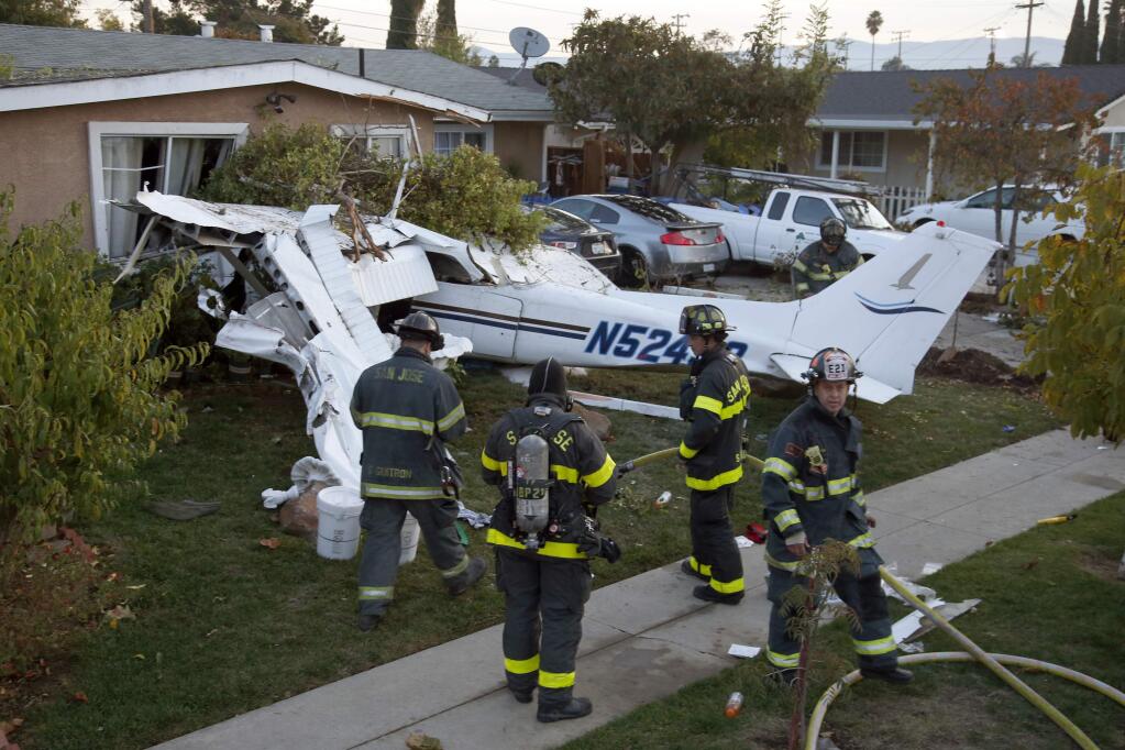 This Sunday, Nov. 19, 2017 photo shows a Cessna 172 that crashed into a home near Reid-Hillview Airport in San Jose, Calif. Authorities say a single-engine plane crashed into the house, injuring all three on board, but no one on the ground. The pilot had just taken off from nearby Reid-Hillview airport Sunday afternoon when he reported a system failure.(Karl Mondon/San Jose Mercury News via AP)