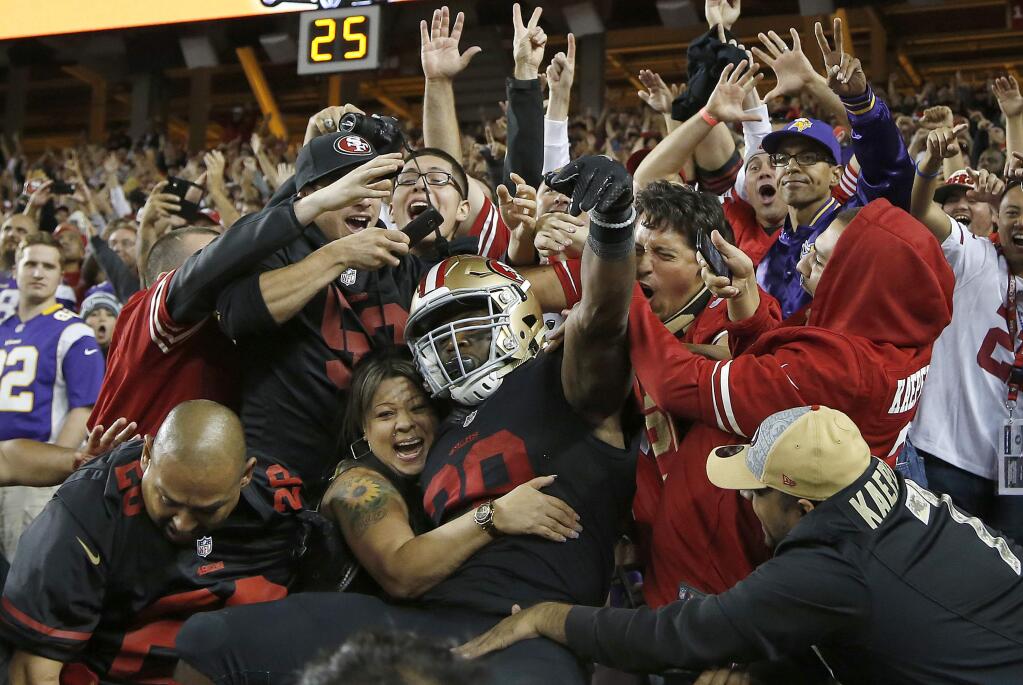 San Francisco 49ers running back Carlos Hyde, center, celebrates with fans after scoring on a 17-yard touchdown run against the Minnesota Vikings during the second half Monday, Sept. 14, 2015. (AP Photo/Tony Avelar)