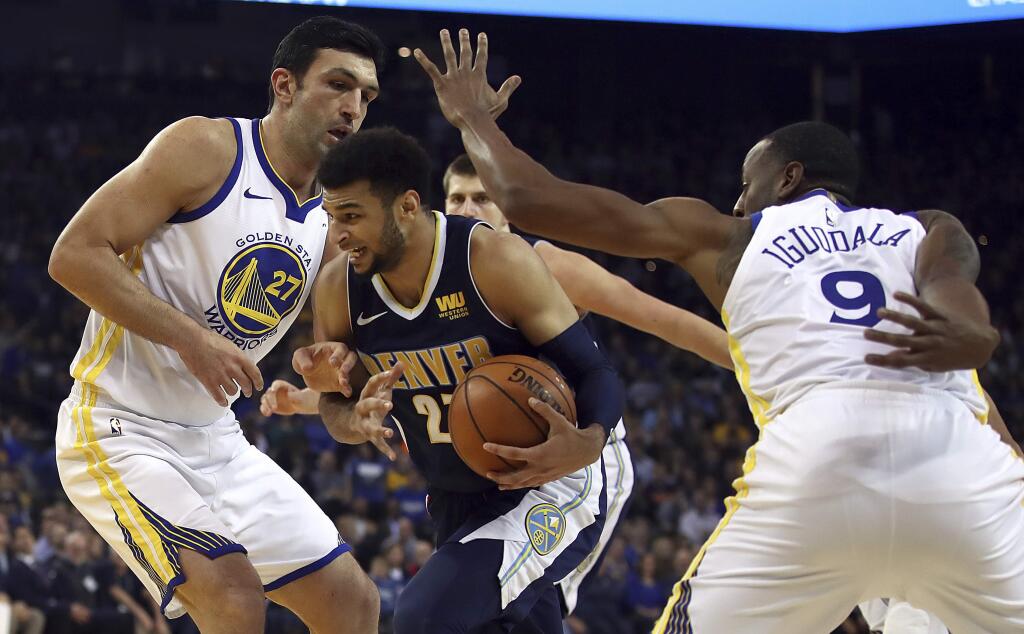 Denver Nuggets' Jamal Murray, center, drives the ball between Golden State Warriors' Zaza Pachulia, left, and Andre Iguodala (9) during the first half of an NBA basketball game Monday, Jan. 8, 2018, in Oakland, Calif. (AP Photo/Ben Margot)
