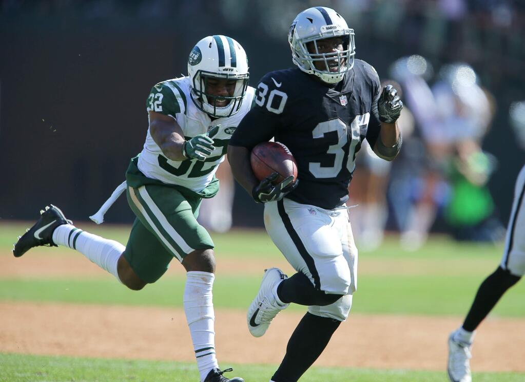 Oakland Raiders running back Jalen Richard breaks away from New York Jets cornerback Juston Burris to get into the end zone for a touchdown, during their game in Oakland on Sunday, September 17, 2017. (Christopher Chung/ The Press Democrat)