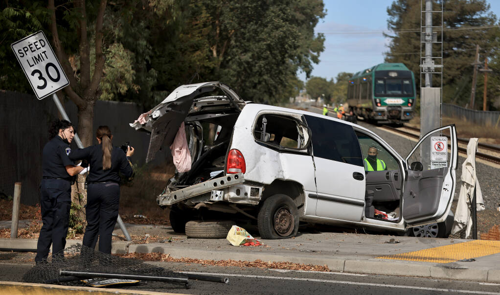 Evidence technicians with the Santa Rosa Police Department investigate the scene of a vehicle versus  SMART train, at the West Steele Lane crossing, Wednesday. Oct. 13, 2021, in Santa Rosa.  (Kent Porter / The Press Democrat) 2021