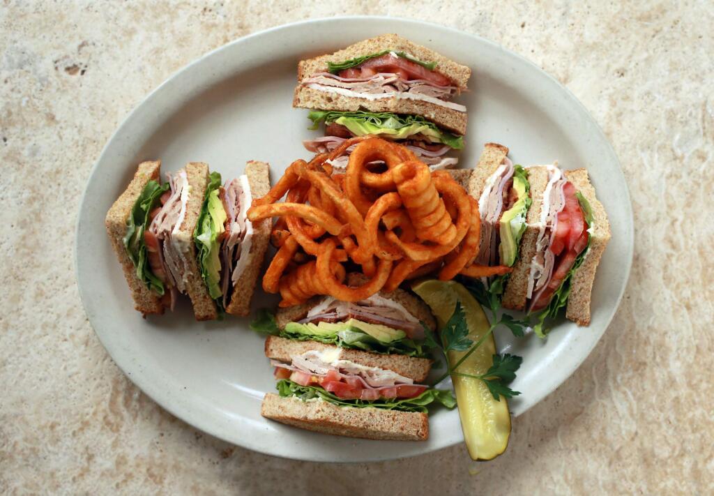 The Club Sandwich with avocado and seasoned curly fries from Mac's Deli in downtown Santa Rosa. (photo by John Burgess/The Press Democrat)