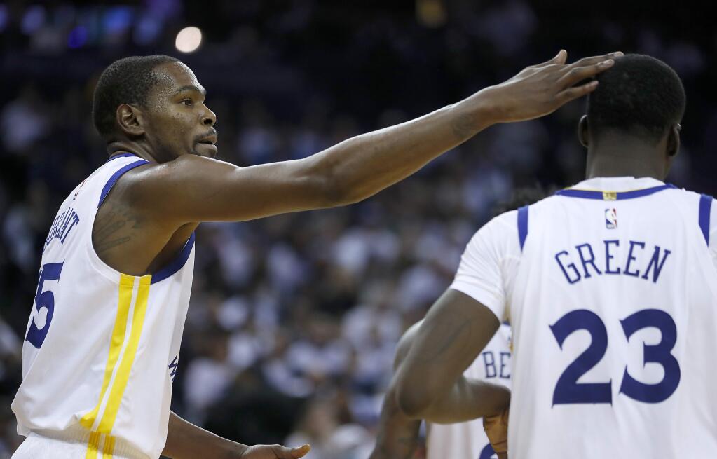 Golden State Warriors forward Kevin Durant taps forward Draymond Green on the head after scoring against the Cleveland Cavaliers during the second half in Oakland, Monday, Dec. 25, 2017. The Warriors won 99-92. (AP Photo/Tony Avelar)