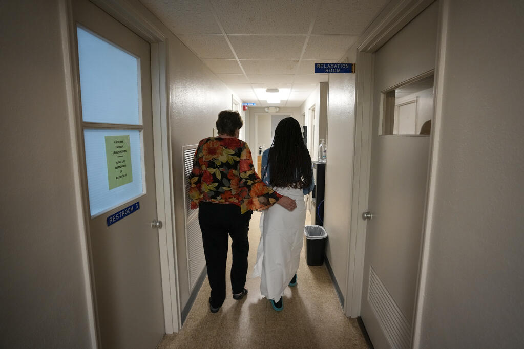 A patient from central Texas is escorted down the hall by clinic administrator Kathaleen Pittman prior to getting an abortion at Hope Medical Group for Women in Shreveport, Louisiana on Oct. 9, 2021. Photo by Rebecca Blackwell, AP Photo