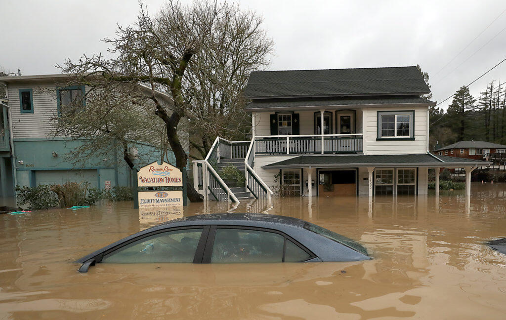 Submerged cars and businesses along Mill Street in Guerneville, Wednesday, Feb. 27, 2019. (Kent Porter / The Press Democrat) 2019