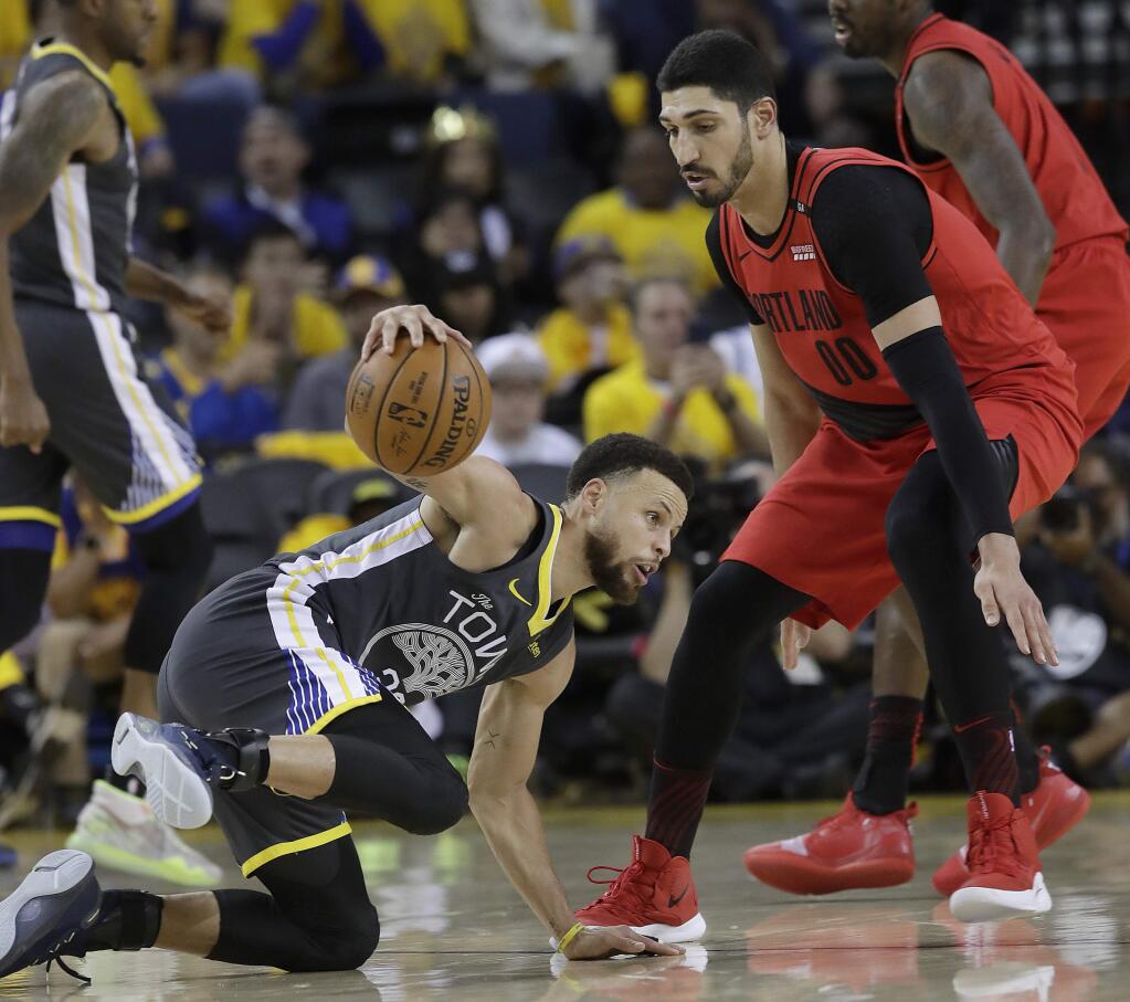 Golden State Warriors guard Stephen Curry, left, dribbles the ball next to Portland Trail Blazers center Enes Kanter (00) during the second half of Game 2 of the NBA basketball playoffs Western Conference finals in Oakland, Calif., Thursday, May 16, 2019. (AP Photo/Jeff Chiu)