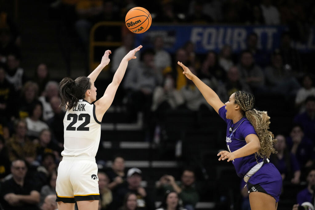 Iowa guard Caitlin Clark shoots a 3-point basket over Holy Cross guard Simone Foreman in the first half of a first-round game in the NCAA Tournament, Saturday, March 23, 2024, in Iowa City, Iowa. (Matthew Putney / ASSOCIATED PRESS)