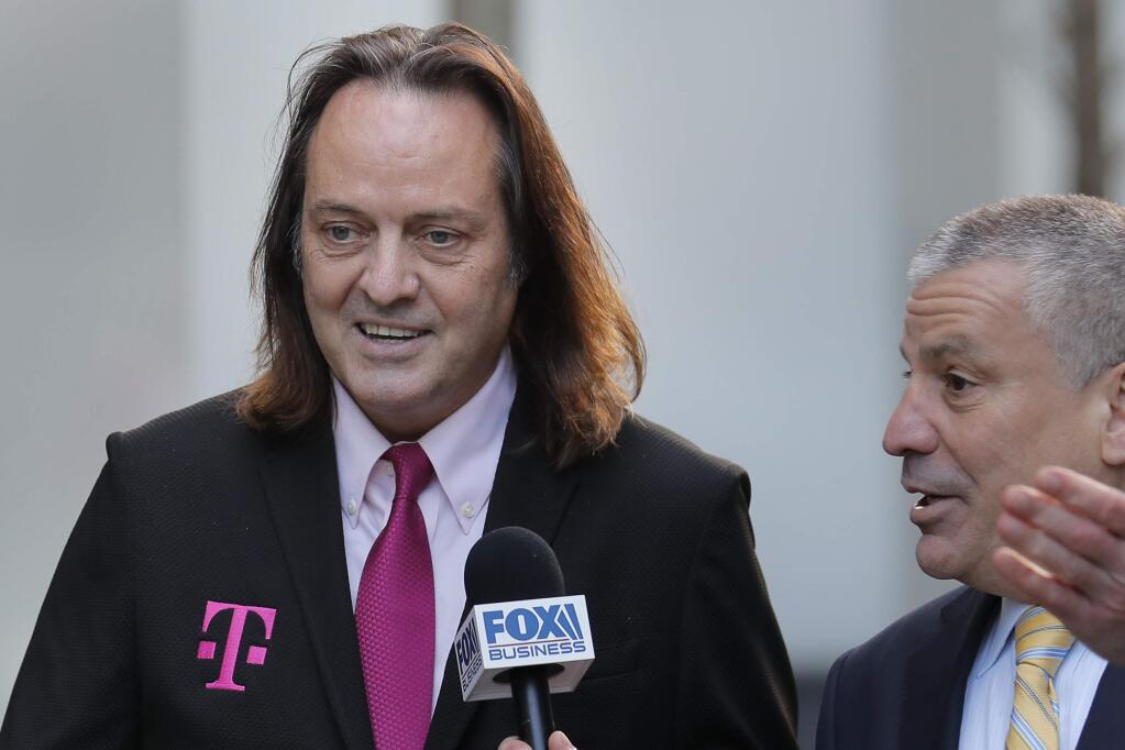 T-Mobile chief executive John Legere speaks to reporters as he leaves the courthouse in New York, Wednesday, Jan. 15, 2020. Legere was in court to hear closing arguments in the case that could permit T-Mobile to merge with Sprint. (AP Photo/Seth Wenig)