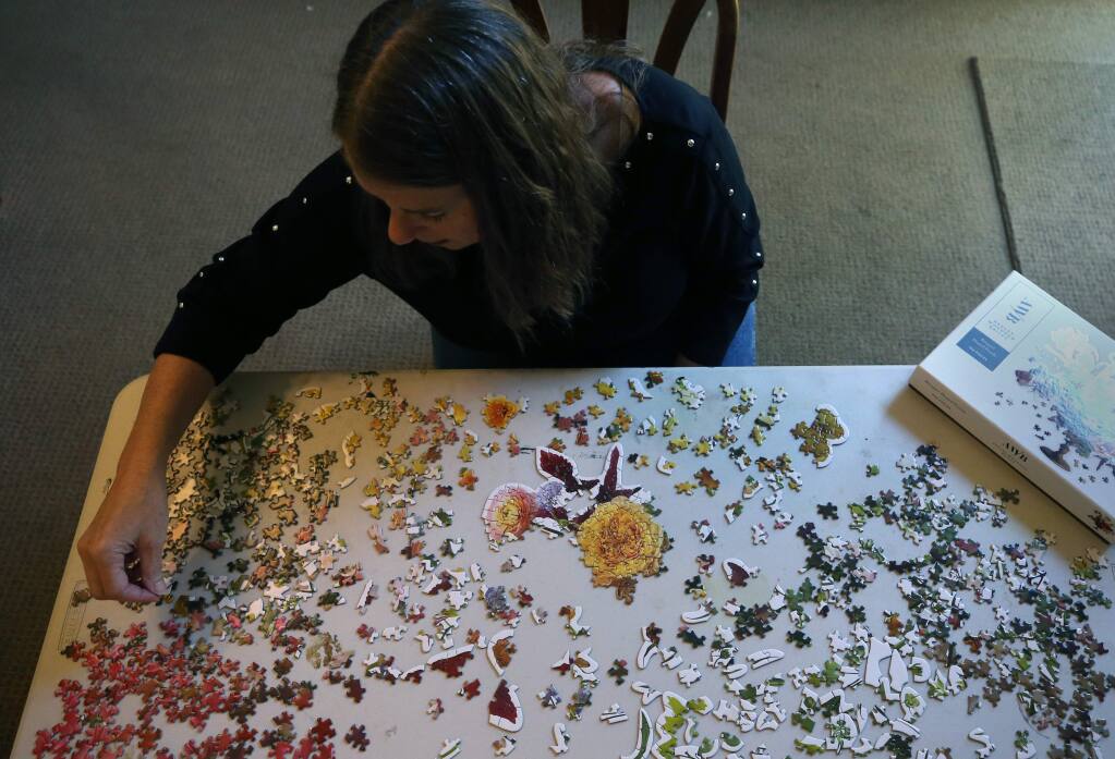 Nancy Woods works on a puzzle at her home in Rohnert Park, California on Wednesday, April 15, 2020. (BETH SCHLANKER/ The Press Democrat)