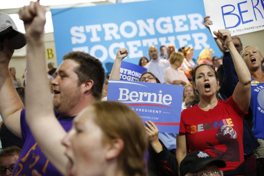 Supporters for Democratic presidential candidates Hillary Clinton and Sen. Bernie Sanders, I-Vt. cheer before a rally in Portsmouth, N.H., Tuesday, July 12, 2016, prior to the arrival of Clinton and Sanders. Sanders is poised to offer his long-awaited endorsement of Clinton, hoping to transfer the energy of his supporters into the party's fight against Republican Donald Trump. (AP Photo/Andrew Harnik)