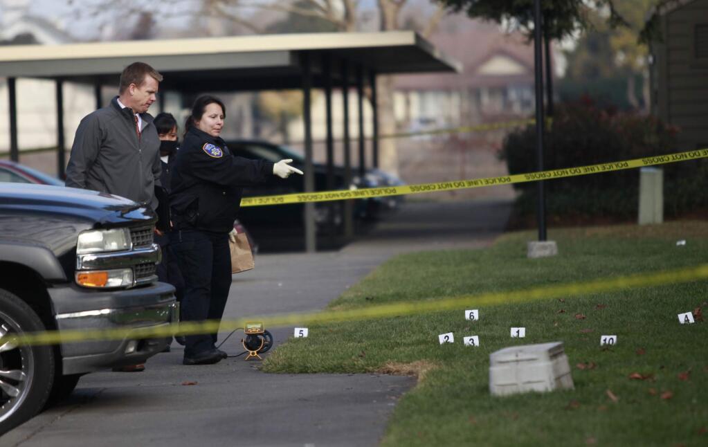 Santa Rosa police detective Stephen Bussel and field evidence technician Adria Cooper investigate a fatal shooting that occurred in the early morning at Redwood Park Apartments in Santa Rosa on Tuesday, Dec. 31, 2013. (BETH SCHLANKER/ PD FILE)