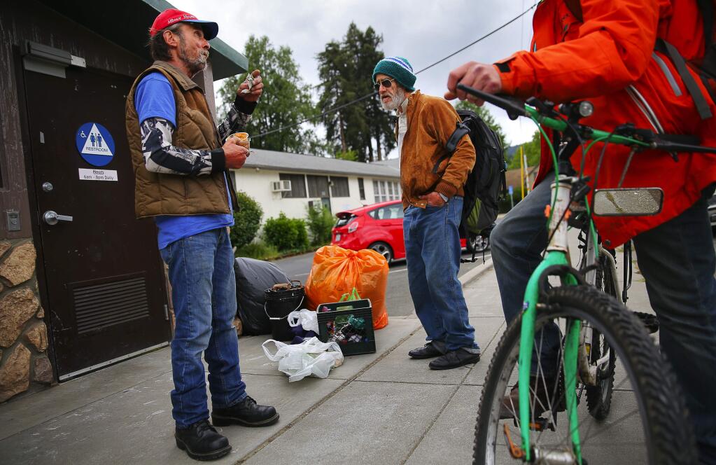 Homeless men Rusty Landry, left, and Peter Parks talk along 1st Street, near the Veterans Memorial Building in Guerneville Monday, April 24, 2017. (Christopher Chung/ The Press Democrat)
