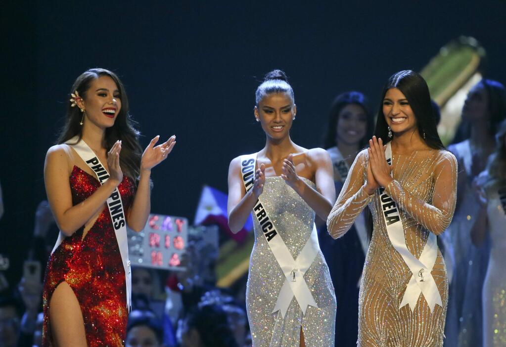 Miss Philippines Catriona Gray, left, Miss South Africa Tamaryn Green, center, applaud as Miss Venezuela Sthefany Gutierrez, right was announced as the second-runner up of the 67th Miss Universe competition in Bangkok, Thailand, Monday, Dec. 17, 2018. (AP Photo/Gemunu Amarasinghe)