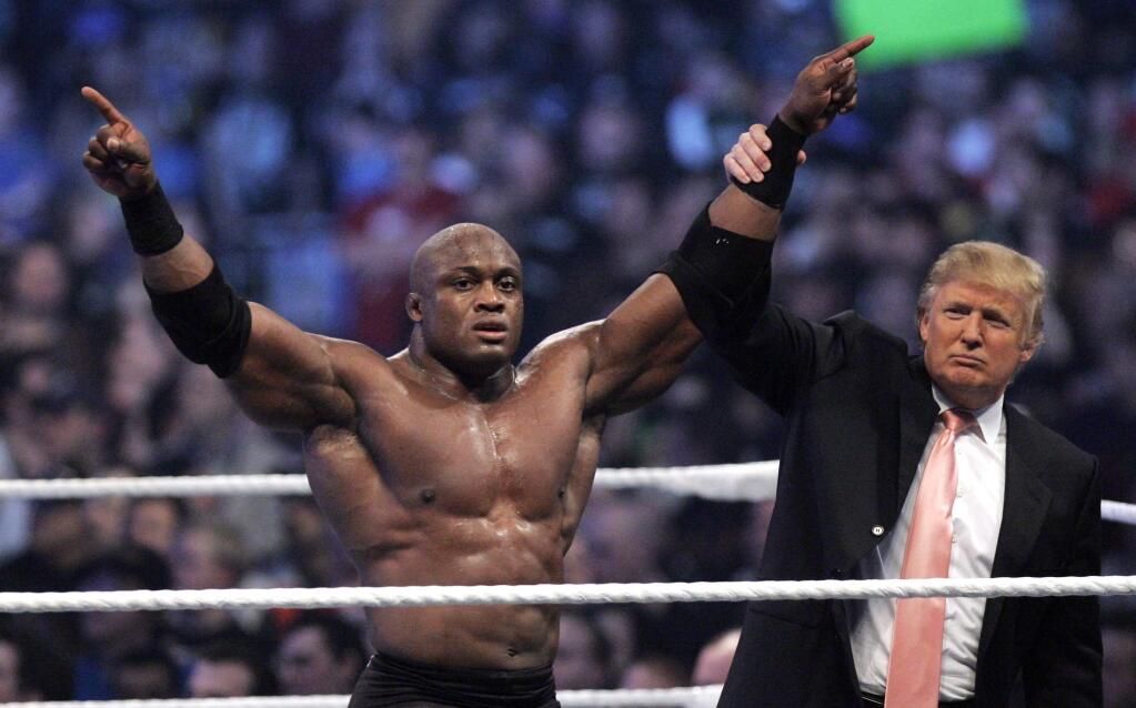 FILE - In this Sunday, April 1, 2007, file photo, Donald Trump raises the arm of wrestler Bobby Lashley after he defeated Umaga at Wrestlemania 23 at Ford Field in Detroit. Trump body-slammed and then shaved the head of WWE boss Vince McMahon after what was known as the “Battle of the Billionaires.' Wrestling aficionados say the president has, consciously or not, long borrowed the time-tested tactics of the game to cultivate the ultimate antihero character, a figure who wins at all costs, incites outrage and follows nobody's rules but his own. (AP Photo/Carlos Osorio, File)