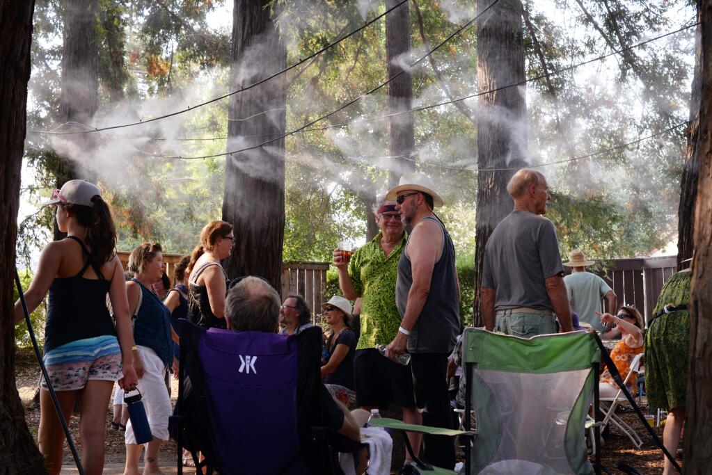 As temperatures hit around 103 degrees Fahrenheit a steady crowd tries to stay cool under the misters during the 22nd annual Sonoma County Cajun Zydeco & Delta Rhythm Festival held Saturday at Ives Park in Sebastopol. September 2, 2017.(Photo: Erik Castro/for The Press Democrat)