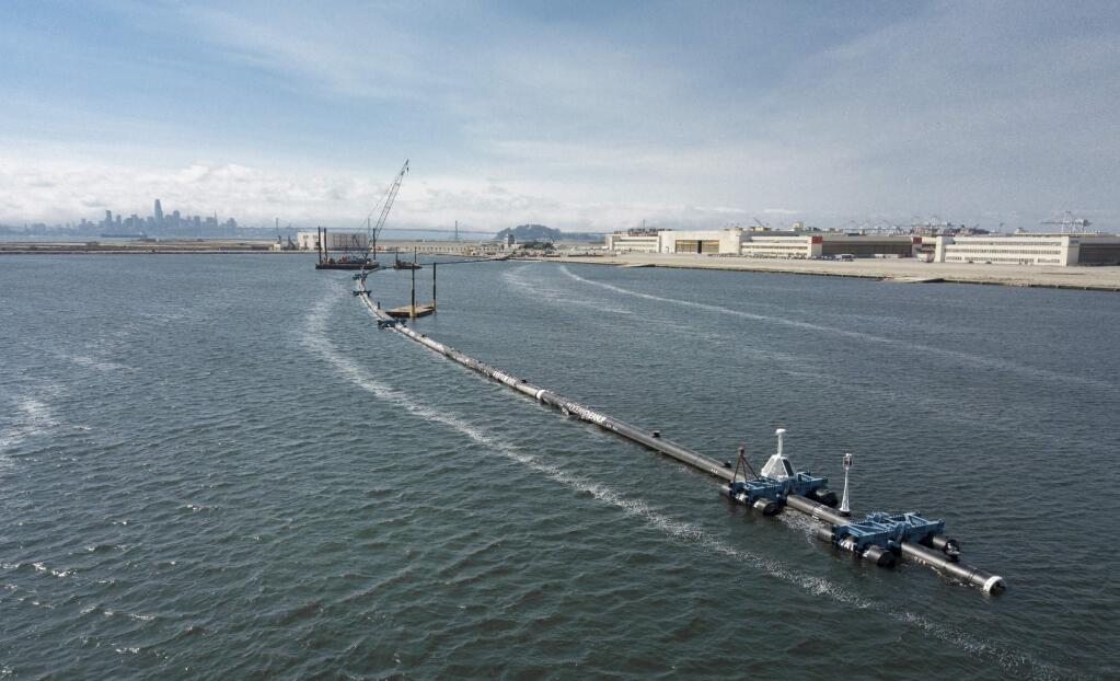 In this Monday, Aug. 27, 2018 photo provided by The Ocean Cleanup, a long floating boom that will be used to corral plastic litter in the Pacific Ocean is assembled in Alameda, Calif. Engineers will deploy a trash collection device to corral plastic litter floating between California and Hawaii in an attempt to clean up the world's largest garbage patch. The 2,000-foot (600-meter) long floating boom will be towed Saturday, Sept. 8, 2018, from San Francisco to the Great Pacific Garbage Patch, an island of trash twice the size of Texas. (The Ocean Cleanup via AP)