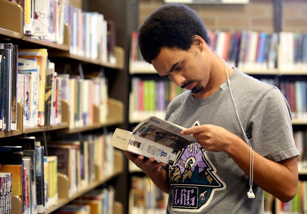 Aldo Ellis, of Santa Rosa looks at book options at the Sonoma County Library in downtown Santa Rosa, Sunday, October 19, 2014. (Crista Jeremiason / The Press Democrat)