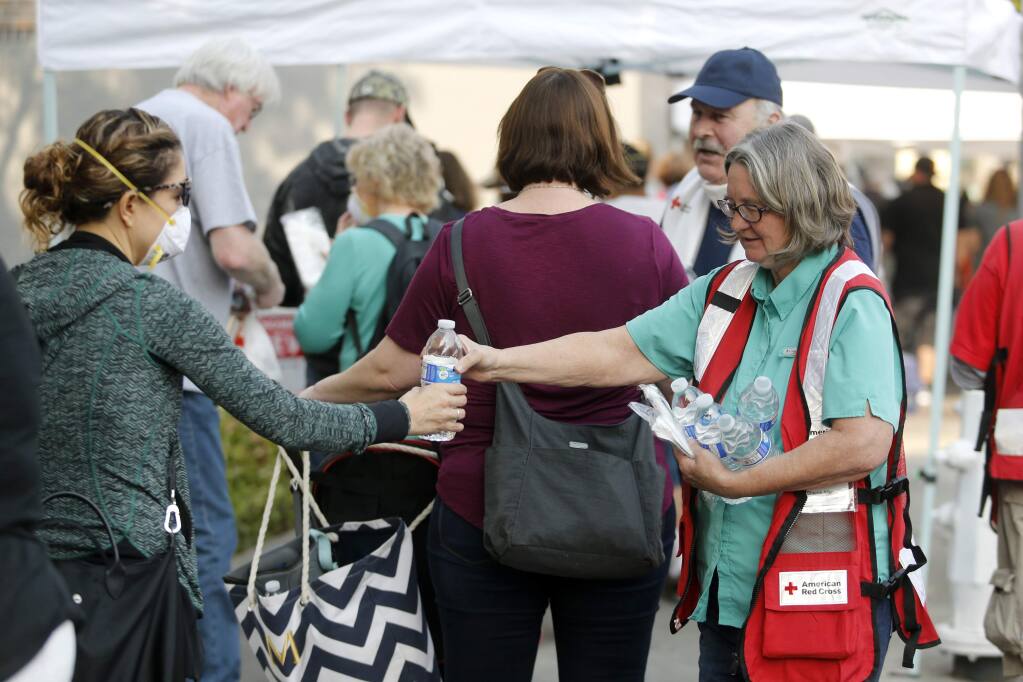 American Red Cross volunteer Sherrie Allen hands out water bottles at the FEMA hub at 427 Mendocino Ave in Santa Rosa, on Monday, October 16, 2017. (BETH SCHLANKER/ The Press Democrat)