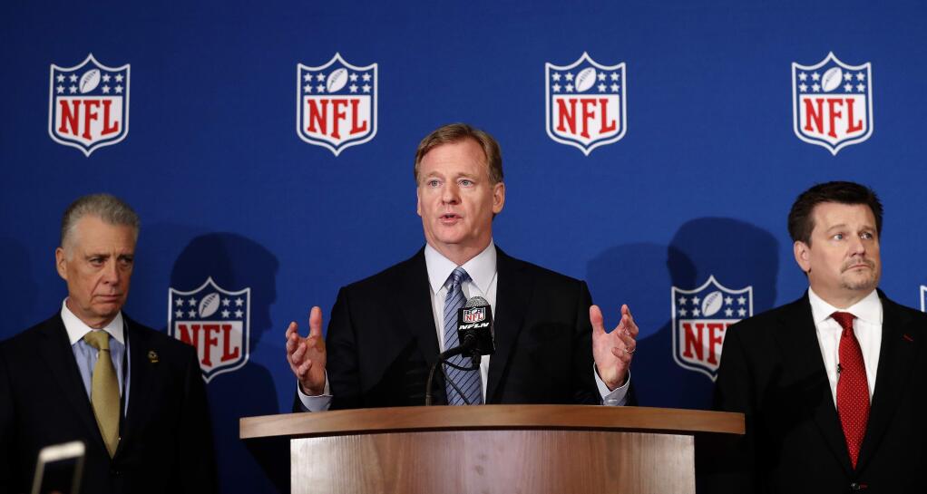 NFL commissioner Roger Goodell, center, is flanked by Pittsburgh Steelers president Art Rooney II, left, and Arizona Cardinals owner Michael Bidwill during a news conference where he announced that NFL team owners have reached agreement on a new league policy that requires players to stand for the national anthem or remain in the locker room, during the NFL owner's spring meeting Wednesday, May 23, 2018, in Atlanta. (AP Photo/John Bazemore)
