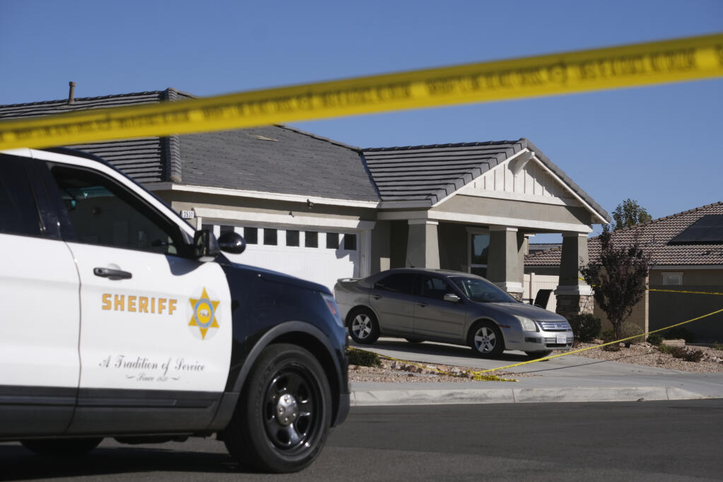 FILE - Los Angeles County Sheriff deputies guard a home in the city of Lancaster in the high desert Antelope Valley north of Los Angeles, Monday, Nov. 29, 2021. A jury convicted a 32-year-old man Tuesday, March 12, 2024, in the 2021 slayings of his four children, including a boy not yet 2 years old and their grandmother, in Southern California. The slayings occurred in the family's home in Lancaster, a city in the Antelope Valley high desert community north of Los Angeles. (AP Photo/Ringo H.W. Chiu, File)